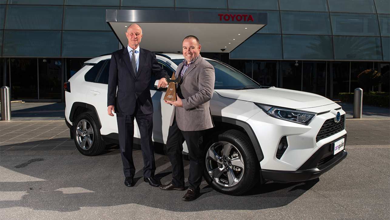Toyota Australia Sales and Marketing boss Sean Hanley accepting the COTY trophy from Malcolm Flynn.